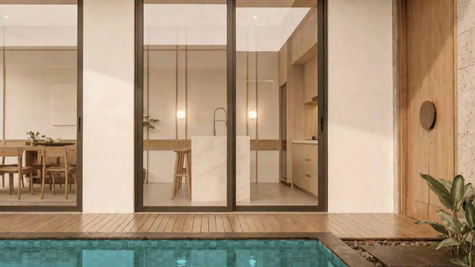 The pool edge meeting a glazed dining room and timber deck.